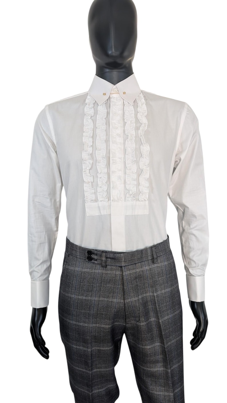 Op de afbeelding: Wit overhemd met een gerimpelde voorkant en een klassieke kraag. Het overhemd wordt gecombineerd met een grijze geruite broek. De mannequin draagt een formele outfit, geschikt voor speciale gelegenheden.