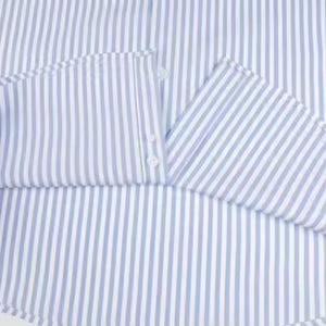 May include: Close-up of a light blue and white striped shirt. The fabric is folded, revealing the inside of the collar and the button closure. The shirt's pattern is a classic vertical stripe.