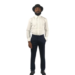 Op de afbeelding: Een formele outfit met een wit overhemd met een gerimpelde voorkant, gecombineerd met marineblauwe broek. De outfit wordt gecompleteerd met een zwarte hoed. Het overhemd heeft lange mouwen en de broek heeft een klassieke pasvorm.