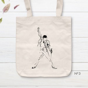 Puede incluir: Una bolsa de tela blanca con un dibujo de línea negra de una persona cantando con un micrófono. El texto "N°3" está impreso en la esquina inferior derecha de la bolsa.