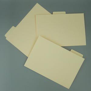 May include: Three cream-colored file folders arranged in an overlapping pattern. Each rectangular folder features a single tab positioned along the top edge, providing a clean and uniform appearance for document organization and storage needs.