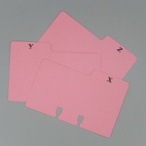 May include: Three pink index cards with tabs, labeled "X", "Y", and "Z" in black lettering.