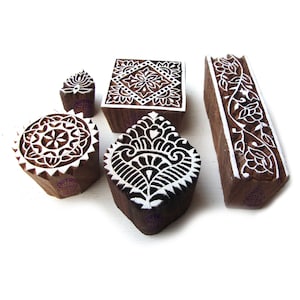 Può includere: Set di cinque blocchi di stampa in legno con intricati disegni floreali e geometrici. I blocchi sono intagliati con vernice bianca e sono pronti per essere utilizzati per la stampa tessile.