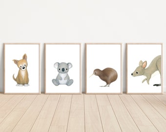 May include: Four framed prints featuring illustrations of Australian animals. The prints are in a light wood frame and feature a brown and white dog, a gray koala, a brown kiwi bird, and a gray kangaroo.