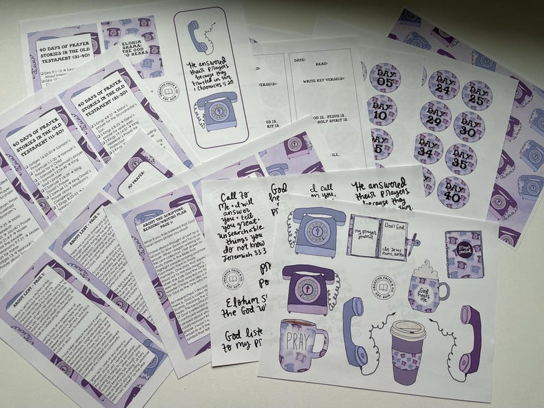 May include: A selection of printed items in purple and white, including prayer guides, stickers, and bookmarks. The designs feature telephones, mugs, and text. The text includes phrases such as "40 Days of Prayer" and Bible verses.