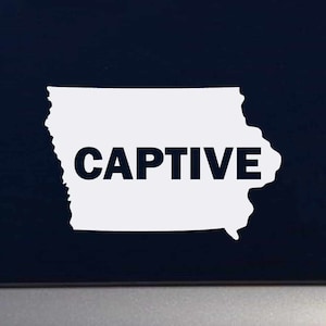 May include: White vinyl sticker of the state of Iowa with the word "CAPTIVE" in black lettering.