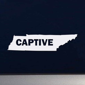 May include: White vinyl sticker of the state of Tennessee with the word "CAPTIVE" in black lettering.