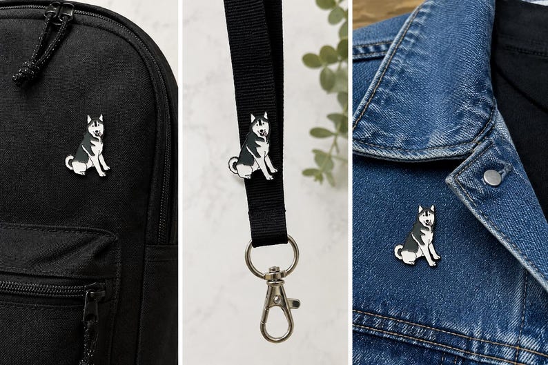 May include: A black and white enamel pin shaped like a sitting Siberian Husky dog. The pin is shown attached to a black backpack, a black fabric lanyard with a silver metal lobster clasp, and the collar of a blue denim jacket.