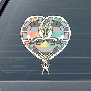 May include: Two snakes intertwined in a heart shape, with a grey, white, yellow, pink, and blue striped background. The snakes are white with black and grey markings.