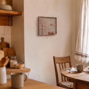 Puede incluir: Un reloj de pared rectangular con marco de madera gris, que presenta una escultura de &aacute;rbol de alambre color cobre en el lado izquierdo y tres peque&ntilde;as figuras color cobre sentadas en el borde inferior. Las manecillas son color cobre.