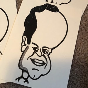 May include: Black and white caricature drawing of a person with a large head and a small body. The person has a large, round head with a small, pointed chin. The person's eyes are large and round, and the person's mouth is open in a smile.