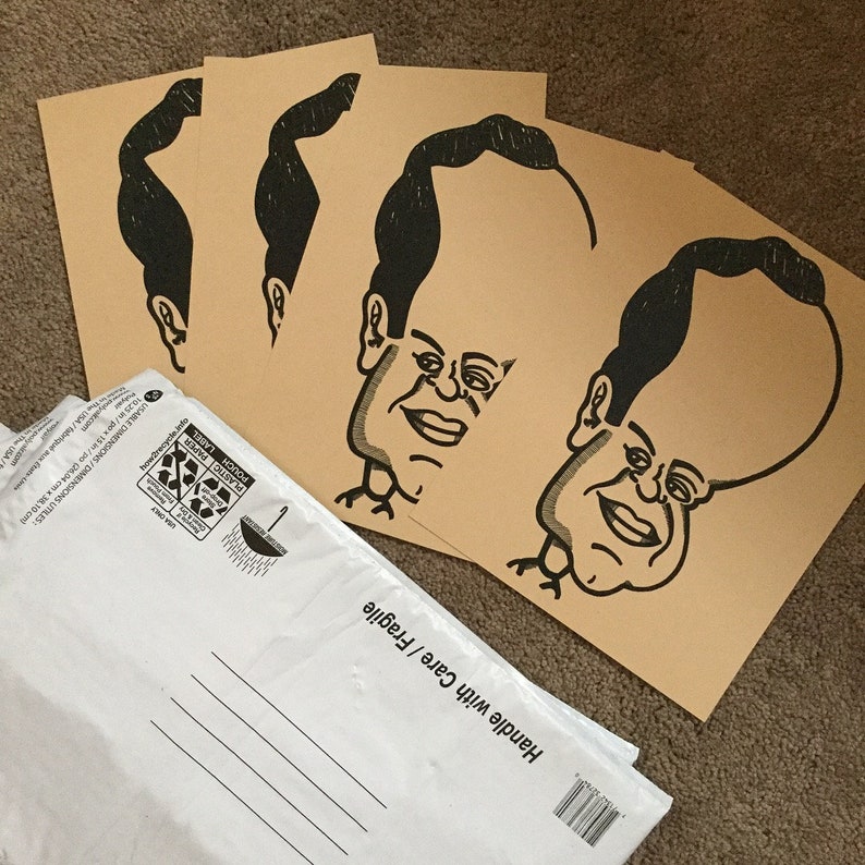 May include: Four brown paper cards with black ink illustrations of a person with a large head and a small body. The text on the cards reads "Handle with Care / Fragile".