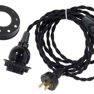 May include: Black electrical cord with an inline switch and a plug. The cord is attached to a black light bulb socket.