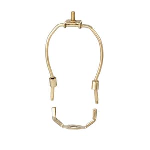 May include: A gold metal lamp harp with a round base and two curved arms. The harp is designed to hold a lampshade.