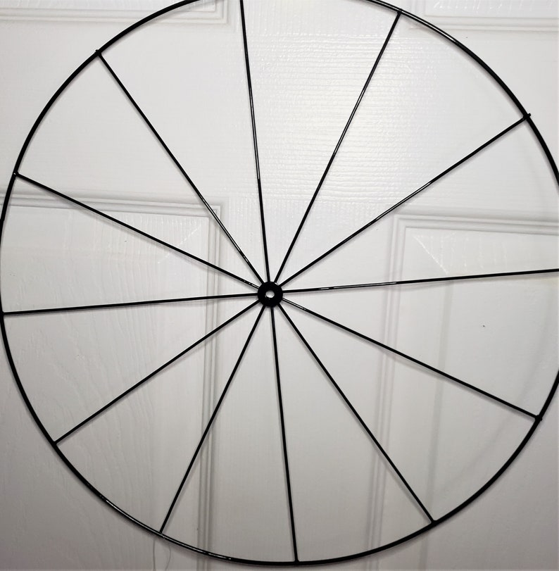 May include: A black metal wreath frame with 16 spokes. The frame is circular and has a diameter of approximately 12 inches.
