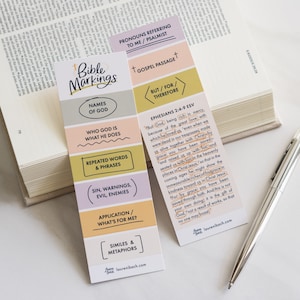 May include: A colorful bookmark with a Bible study guide. The bookmark is divided into sections with titles like "Names of God", "Who God Is", "What He Does", "Repeated Words & Phrases", "Sin, Warnings, Evil, Enemies", "Application/What's For Me?", "Similes & Metaphors", "Pronouns Referring to Me/Psalmists", "Gospel Passage", "But/For/Therefore". The bookmark also includes a Bible verse from Ephesians 2:4-9.