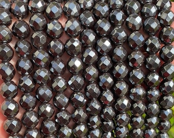 May include: A strand of faceted black hematite beads. The beads are round and have a shiny, metallic finish.