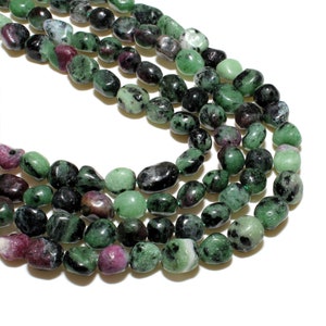 May include: A strand of green, black, and pink gemstone beads. The beads are smooth and oval-shaped.