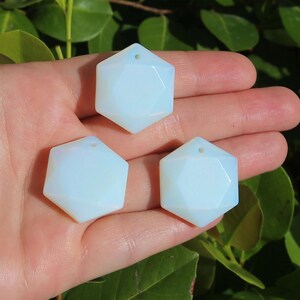May include: Three white opal gemstone pendants in the shape of a six-pointed star with a hole at the top for stringing.