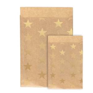 Könnte beinhalten: Zwei braune Papiertüten mit goldenen Sternenmustern. Die größere Tüte befindet sich hinter der kleineren.
