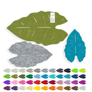 Könnte beinhalten: Ein Set Filz-Untersetzer in Blattform in verschiedenen Farben, darunter Grün, Grau und Blau. Die Untersetzer sind aus Filz und haben ein Blattdesign. Die Untersetzer sind in einem Raster angeordnet. Der Text "FILZ" ist auf einem der Untersetzer sichtbar.