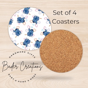May include: Set of four coasters featuring a blue cartoon character drawing hearts on a white background. The coasters are made of cork and have a natural brown color. The text "Set of 4 Coasters" is printed in black at the top of the image. The text "Handmade Gifts Bader Creations Baby Home More" is printed in black at the bottom of the image.