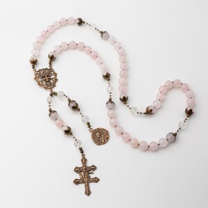 The Saint Joan of Arc rosary is shown with a white background.  It is spread out to so no beads are overlapping one another.
