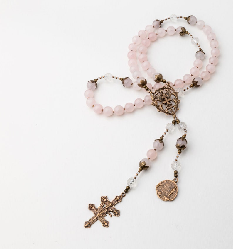 the Saint Joan of Arc rosary is presented on a white background with the five decades loop folded over itself