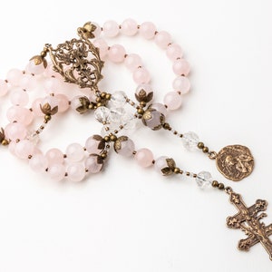 This Saint Joan of Arc rosary is shown on a white background. The crucifix and center show the cross of Lorraine with thistle which were symbols of Saint Joan of Arc.