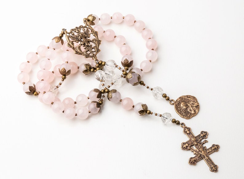 This Saint Joan of Arc rosary is shown on a white background. The crucifix and center show the cross of Lorraine with thistle which were symbols of Saint Joan of Arc.