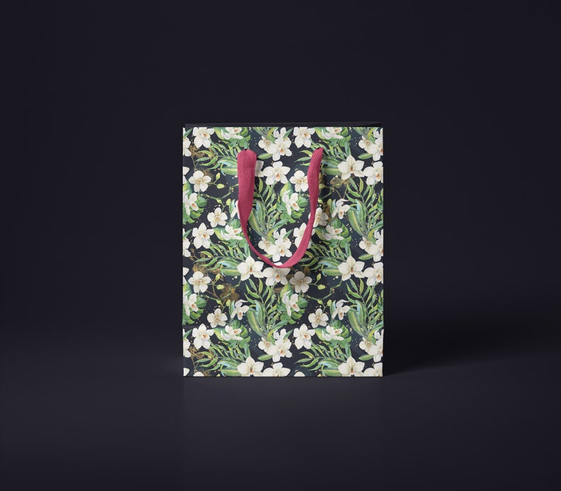 May include: A white gift bag with a floral pattern featuring white orchids and green leaves. The bag has red handles.