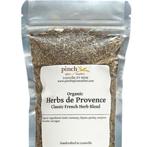 Pu&ograve; includere: Un sacchetto richiudibile argentato pieno di erbe secche etichettato "Organic Herbs de Provence Classic French Herb Blend". L'etichetta include anche il testo "pinch spice market Louisville, KY 40206 www.pinchspicemarket.com" e "Handcrafted in Louisville".