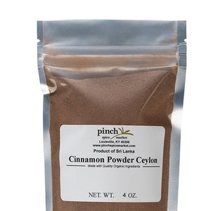 May include: A silver resealable pouch containing brown Ceylon cinnamon powder. The white label reads: pinch spice market, Louisville, KY 40206, www.pinchspicemarket.com, Product of Sri Lanka, Cinnamon Powder Ceylon, Made with Quality Organic Ingredients, NET. WT. 4 OZ.