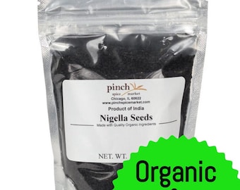 Könnte beinhalten: Ein wiederverschließbarer Beutel mit schwarzen Nigella-Samen und einem grün-weißen Etikett mit der Aufschrift "Bio & Fair Trade". Das Etikett enthält auch den Text "pinch spice market" und "Produkt aus Indien".