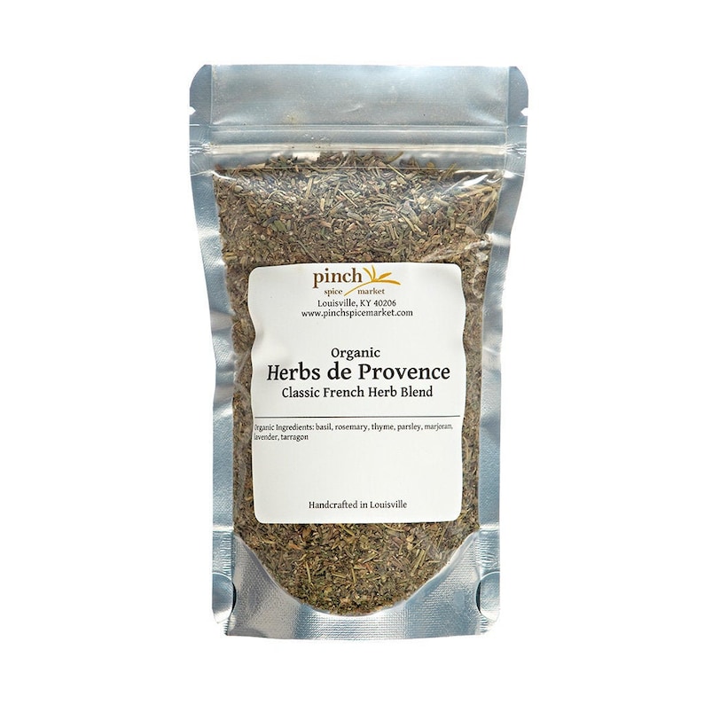 Pu&ograve; includere: Un sacchetto richiudibile argentato pieno di erbe secche etichettato "Organic Herbs de Provence Classic French Herb Blend". L'etichetta include anche il testo "pinch spice market Louisville, KY 40206 www.pinchspicemarket.com" e "Handcrafted in Louisville".