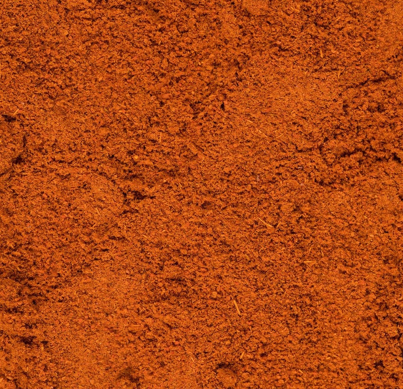 May include: Close-up of a pile of ground cinnamon, a warm brown spice with a slightly reddish hue.