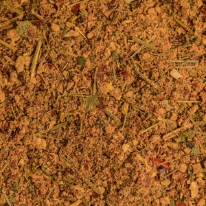 May include: A close-up of a blend of dried herbs and spices, including red pepper flakes, dried herbs, and other spices.