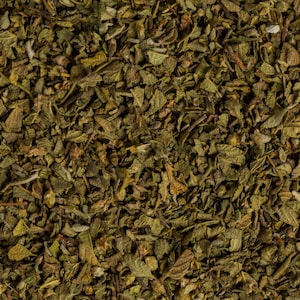 May include: Close-up of dried oregano leaves, a popular herb used in cooking. The leaves are a dark green color and have a slightly brown hue.
