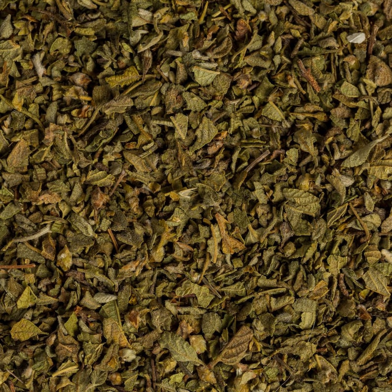 May include: Close-up of dried oregano leaves, a popular herb used in cooking. The leaves are a dark green color and have a slightly brown hue.