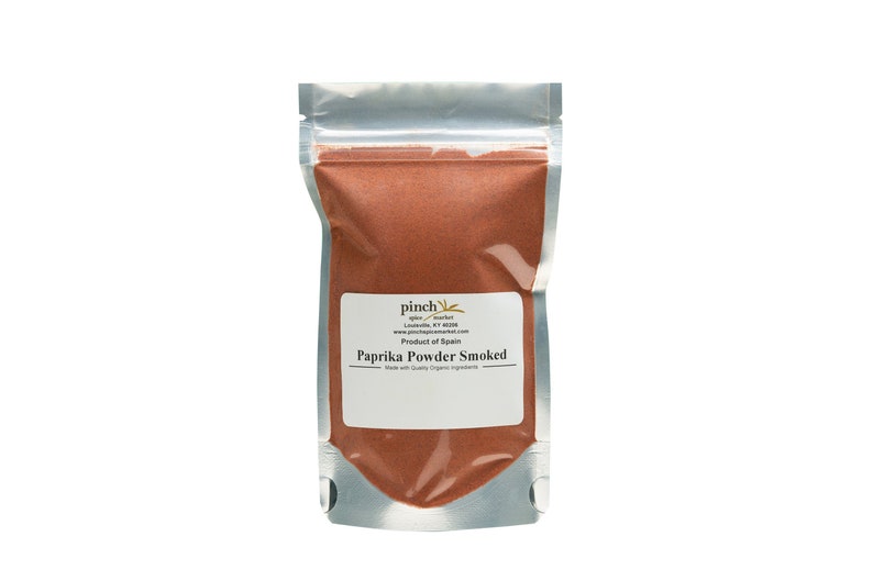 May include: A silver resealable pouch filled with red paprika powder. The label reads "pinch spice + herbs Louisville, KY 40208 www.pinchspicesherbs.com Product of Spain Paprika Powder Smoked Made with Quality Organic Ingredients"