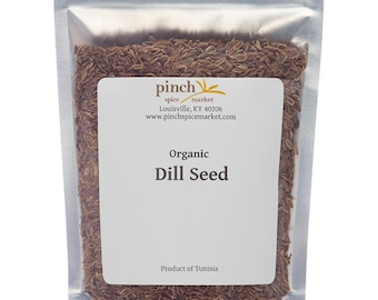 May include: A resealable silver pouch filled with organic dill seed. The pouch has a white label with the text "pinch spice market" and "Organic Dill Seed". The label also includes the company's website address and the text "Product of Tunisia".