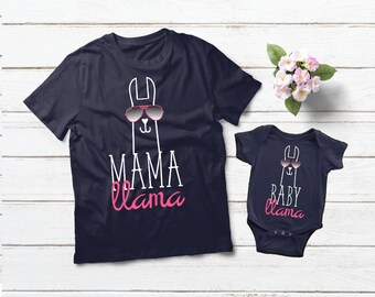 May include: Matching mommy and me t-shirts featuring a llama wearing sunglasses. The adult shirt says "Mama Llama" in white text with "llama" in pink text. The baby shirt says "Baby Llama" in white text with "llama" in pink text.