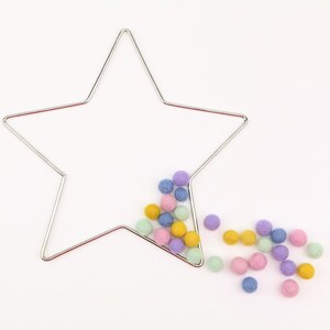May include: A silver wire star-shaped frame with pastel coloured felt balls spilling out of it.