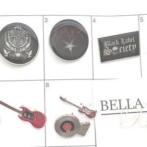 May include: Collection of metal band pins and guitar-shaped pins. Includes pins with the logos of Megadeth, Black Label Society, and Mötley Crüe. Also features pins shaped like electric guitars and a record player.