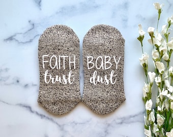May include: A pair of brown and white cozy socks with the text "Faith Trust" on one sock and "Baby Dust" on the other sock.
