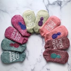 May include: A set of ten colorful ankle socks with pineapple designs and various phrases, including "Lucky Transfer Sock", "Positive Vibes", "Ive got Hope", "Stick Baby Stick", "Mama in the Morning".