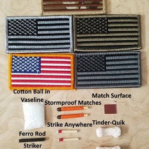May include: A survival kit with a cotton ball in vaseline, stormproof matches, a match surface, a ferro rod, a striker, a tinder wick, and a strike anywhere tinder-quik. The kit is laid out on a wooden surface with four American flag patches.