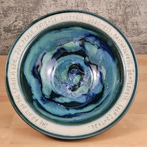 May include: A large, blue and green ceramic bowl with a white rim. The rim is inscribed with the words "The fruit of the spirit is love, joy, peace, patience, kindness, goodness, faithfulness, gentleness, self control."