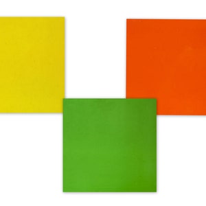 Puede incluir: Tres cuadrados de papel, uno amarillo, uno naranja y uno verde, dispuestos en forma de L.