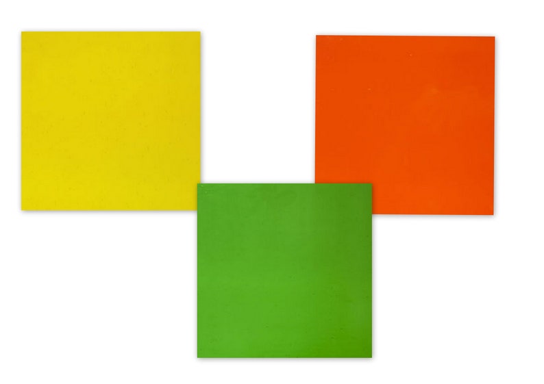 Puede incluir: Tres cuadrados de papel, uno amarillo, uno naranja y uno verde, dispuestos en forma de L.